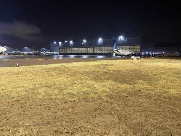 Airport concourse and apron lit at night with aircraft at gates