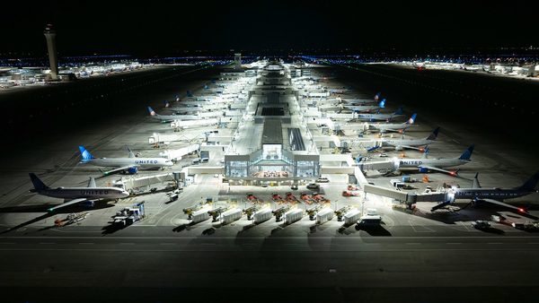 Aerial night view of a Denver International Airport concourse with United Airlines aircraft at the gates